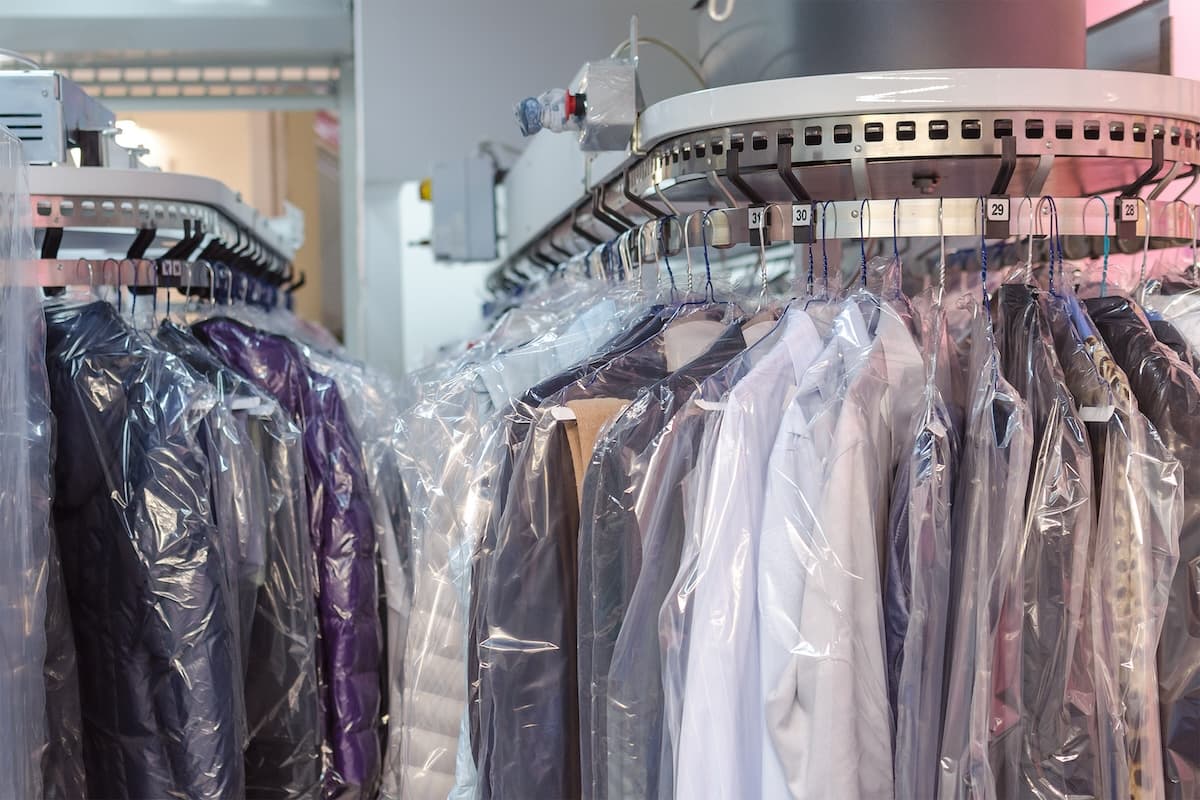 Rows of cleaned garments hanging in clear protective bags on the dry-cleaning rack at Mars Laundromat