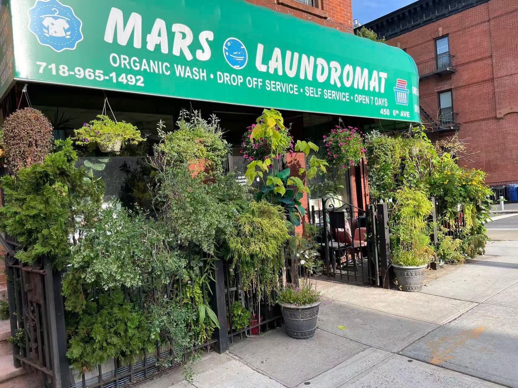 The storefront of Mars Laundromat on a sunny Park Slope street